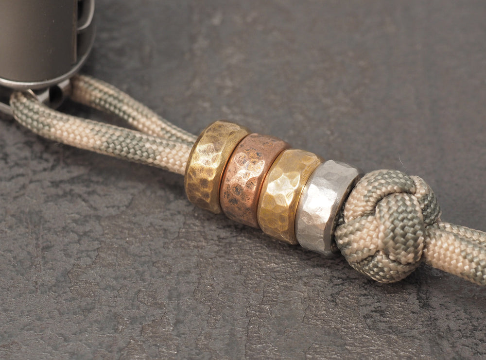 Hammered lanyard spacer beads on paracord lanyard