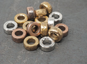 Pile of brass, bronze, copper and stainless steel lanyard spacer beads