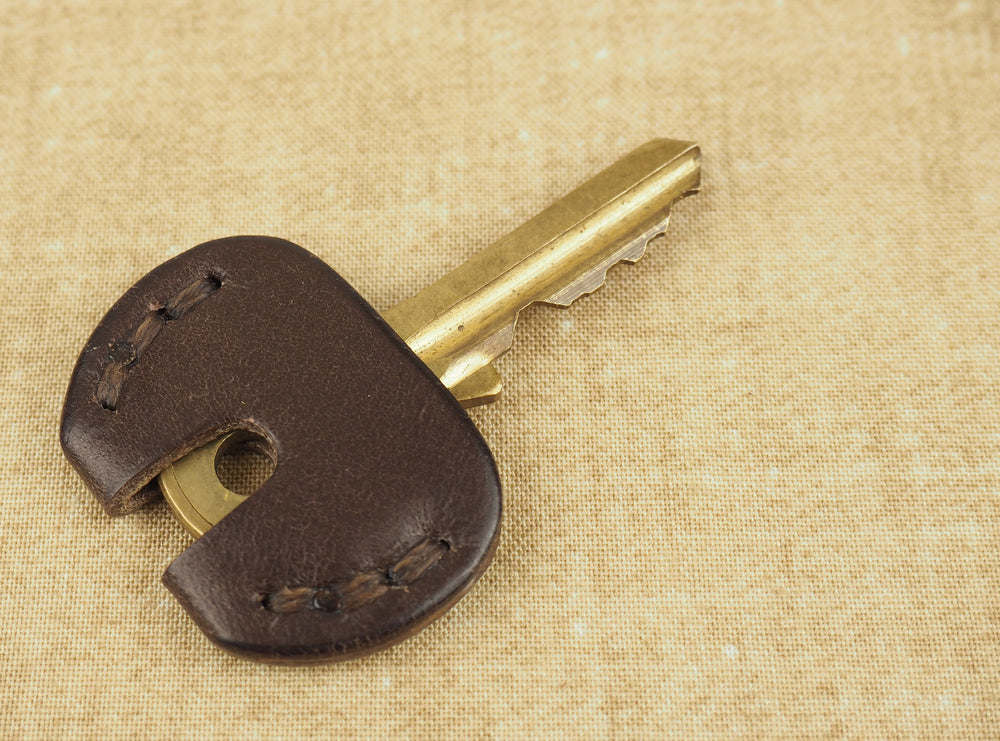 
            
                Load image into Gallery viewer, Leather door key cover installed on brass key
            
        