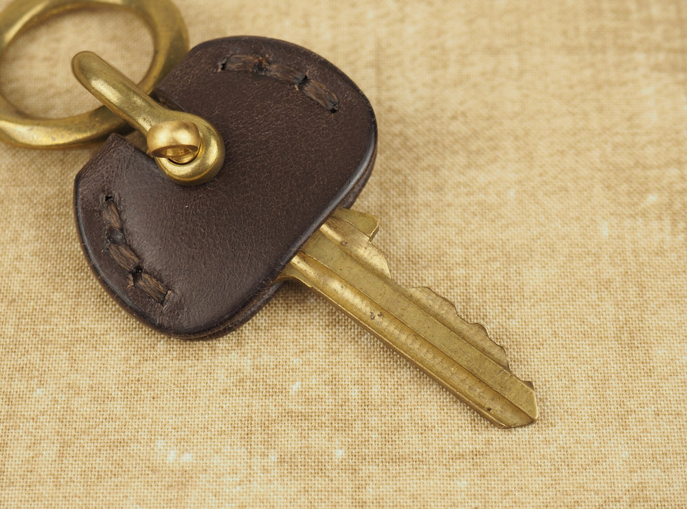 
            
                Load image into Gallery viewer, Brown leather door key cover with brass shackle
            
        